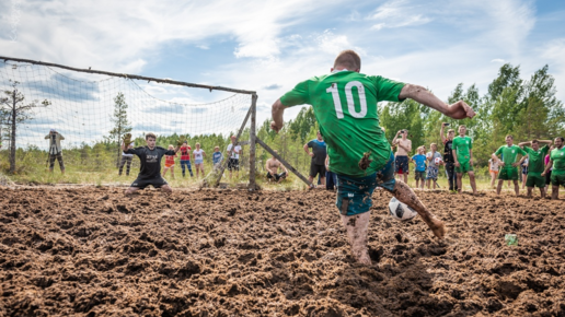 Картинка: Люди играют в футбол по колено в грязи. Зачем?